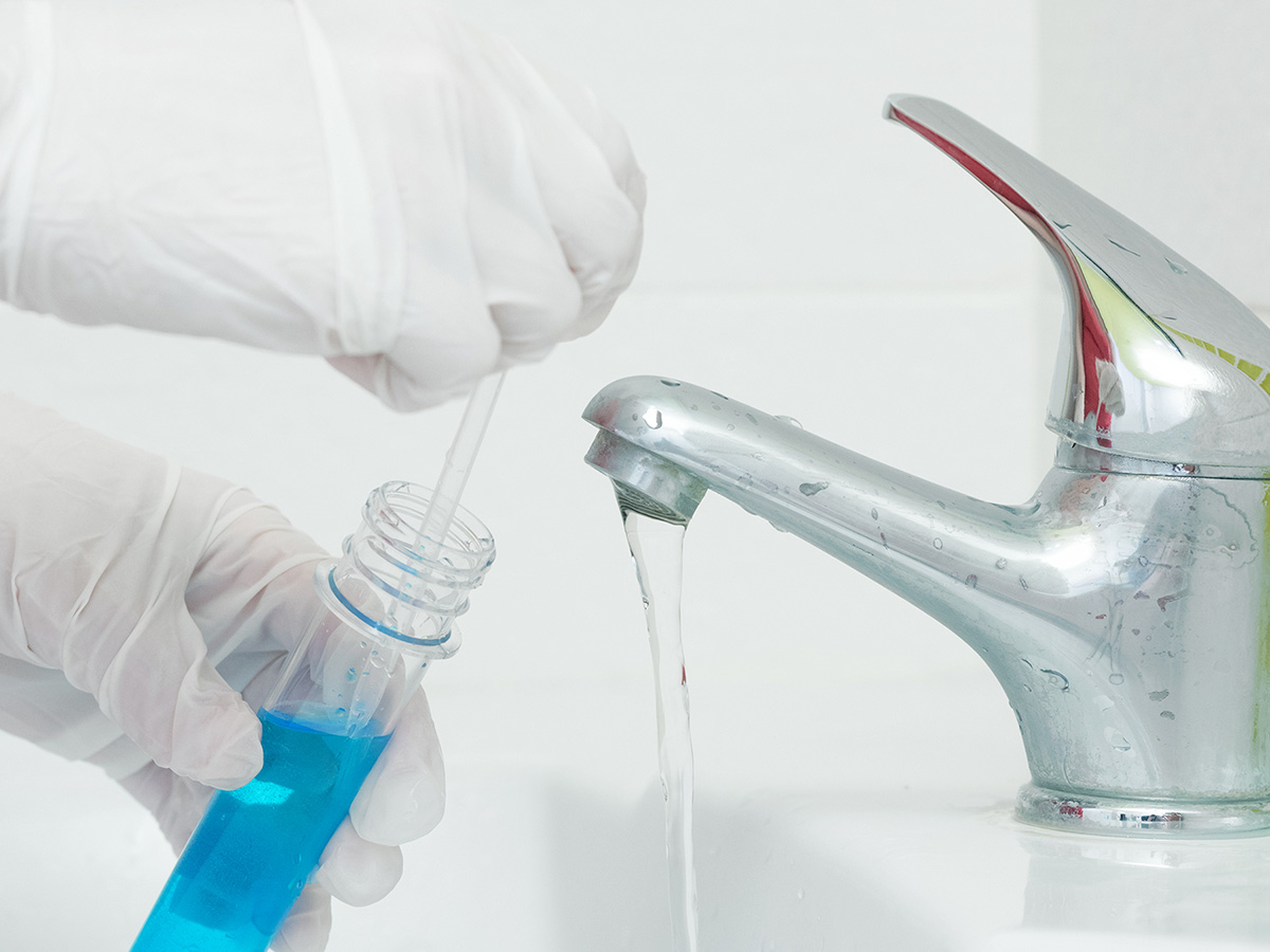Person testing water from a faucet for contaminates
